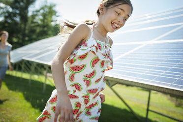 Ein Kind und seine Mutter an der frischen Luft, neben Sonnenkollektoren an einem sonnigen Tag auf einer Farm im Staat New York, USA. - MINF00463