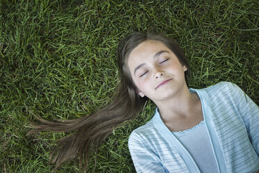 A girl with long hair fanned out, asleep on the grass. - MINF00480