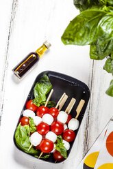 Lunch box of skewered cherry tomatoes and mozzarella cheese balls with basil leaves - SBDF03669