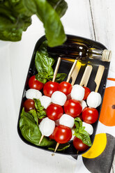 Lunch box of skewered cherry tomatoes and mozzarella cheese balls with basil leaves and vinaigrette - SBDF03670