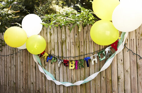 Happy Birthday-Banner und Luftballons am Zaun befestigt - CUF43617