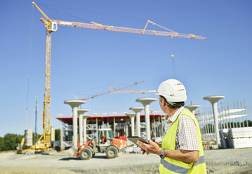 Worker on construction site using digital tablet - CVF00971