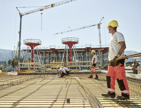 Workers on construction site preparing iron rods stock photo