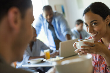 A group of men and women in a cafe, having drinks and enjoying each other's company. - MINF00616