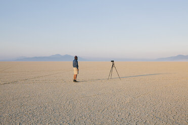 Mann mit Kamera und Stativ auf der flachen Salzpfanne oder Playa der Black Rock Wüste, Nevada. - MINF00723