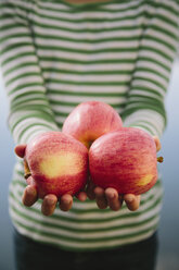 Nine year old girl holding handful of organic apples - MINF00739