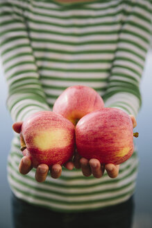 Neunjähriges Mädchen hält eine Handvoll Bio-Äpfel - MINF00739
