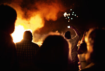 Silhouetten von Menschen um ein großes Lagerfeuer. - MINF00770