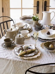 Ein für eine Mahlzeit gedeckter Tisch mit einem weißen Tischtuch und traditionellem weißen Geschirr, Servietten und Besteck. - MINF00806