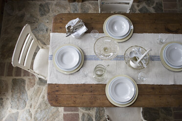Blick von oben auf einen mit weißem Geschirr und Gläsern gedeckten Tisch. - MINF00808