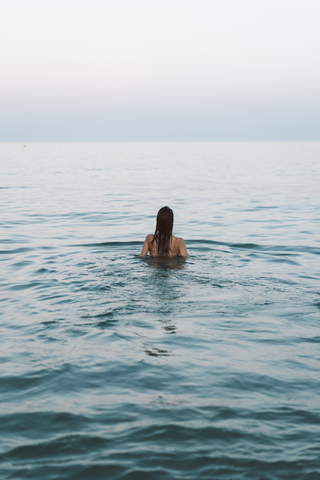 Schöne Frau am Strand, Schwimmen im Meer, lizenzfreies Stockfoto