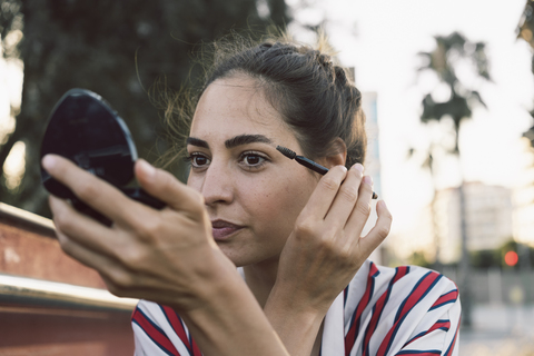 Portrait of woman applying mascara stock photo