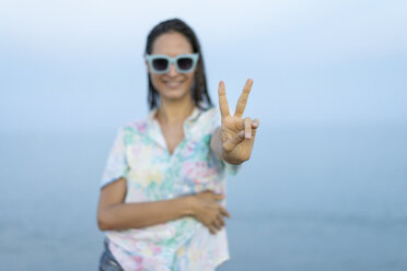 Smiling woman showing victory sign, close-up - AFVF00871