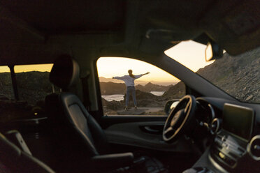 Junge Frau genießt den Sonnenuntergang am Strand, Blick durch das Auto - AFVF00890