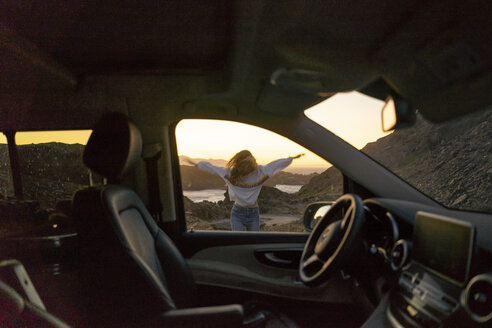 Junge Frau genießt den Sonnenuntergang am Strand, Blick durch das Auto - AFVF00891