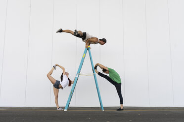 Three acrobats doing tricks on a ladder - AFVF00899