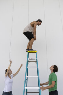 Akrobaten helfen einem Kollegen, einen neuen Trick auszuprobieren - AFVF00904