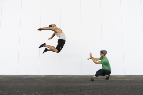 Two acrobats doing tricks together, jumping mid-air stock photo