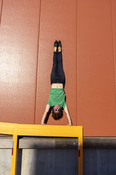 Acrobat performing handstand on yellow frame - AFVF00948