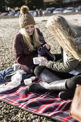 Zwei Mädchen machen ein Winterpicknick am Strand. - MINF00968