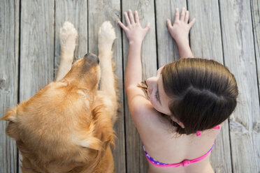 Ein junges Mädchen und ein Golden Retriever Hund Seite an Seite auf einem Steg. - MINF00994