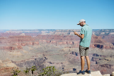 USA, Arizona, Grand Canyon National Park, Grand Canyon, man looking at smartphone - GEMF02167