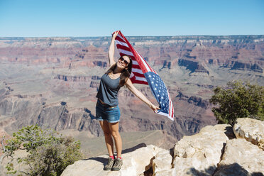 USA, Arizona, lächelnde Frau mit amerikanischer Flagge im Grand Canyon National Park - GEMF02176