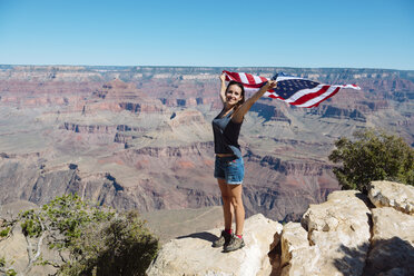 USA, Arizona, lächelnde Frau mit amerikanischer Flagge im Grand Canyon National Park - GEMF02177