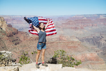 USA, Arizona, lächelnde Frau mit amerikanischer Flagge im Grand Canyon National Park - GEMF02179