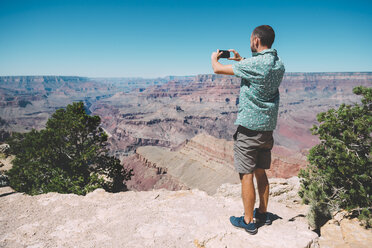 USA, Arizona, Grand Canyon National Park, Grand Canyon, man taking photos with smartphone - GEMF02192