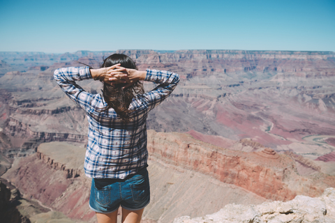 USA, Arizona, Grand Canyon National Park, Grand Canyon, Rückenansicht einer Frau mit Blick auf die Aussicht, lizenzfreies Stockfoto