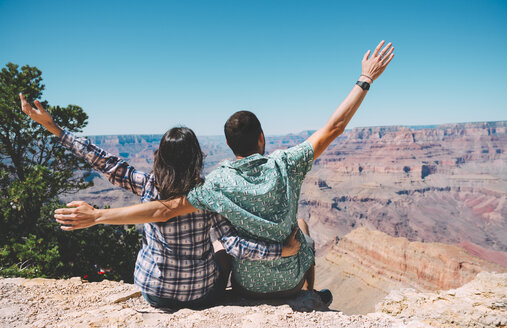 USA, Arizona, Grand Canyon National Park, Rückenansicht eines Paares, das nebeneinander sitzt und die Aussicht betrachtet - GEMF02200
