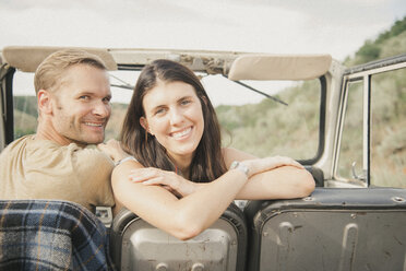 A couple on a road trip in a jeep side by side, a woman looking over her shoulder. - MINF01022