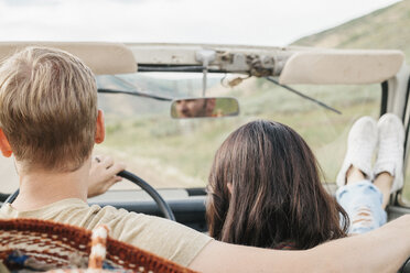 Ein Paar auf einem Ausflug in die Berge in einem offenen Jeep sitzend. - MINF01025