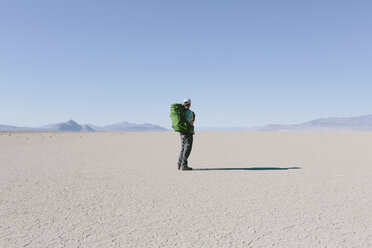 Männlicher Rucksacktourist beim Wandern in der weiten Wüste, Black Rock Desert, Nevada - MINF01056