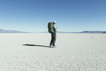 Männlicher Rucksacktourist beim Wandern in der weiten Wüste, Black Rock Desert, Nevada - MINF01057