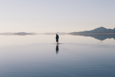 Man walking on vast and flooded Bonneville Salt Flats, Utah - MINF01058