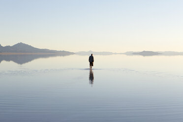 Mann, der durch die weiten und überfluteten Bonneville Salt Flats, Utah, läuft - MINF01059