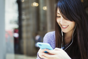 Young Japanese woman enjoying a day out in London, using a smartphone. - MINF01076