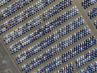 Luftaufnahme eines Autohandelszentrums, in Reihen geparkte Neuwagen auf einem Parkplatz, bereit zum Verkauf. - MINF01118