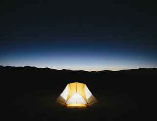 Beleuchtetes Campingzelt in der weiten Wüste in der Abenddämmerung, Black Rock Desert, Nevada - MINF01130