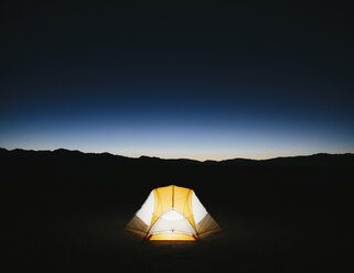 Illuminated camping tent in vast desert at dusk, Black Rock Desert, Nevada - MINF01130