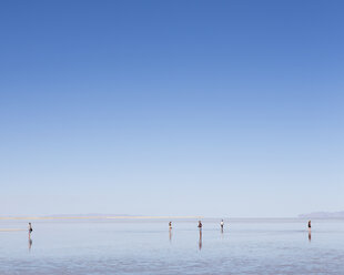 Eine Gruppe von Menschen steht auf den überfluteten Bonneville Salt Flats, Utah - MINF01133