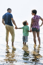 Eine Familie, Mutter, Vater und Sohn spielen am Ufer eines Sees. - MINF01250