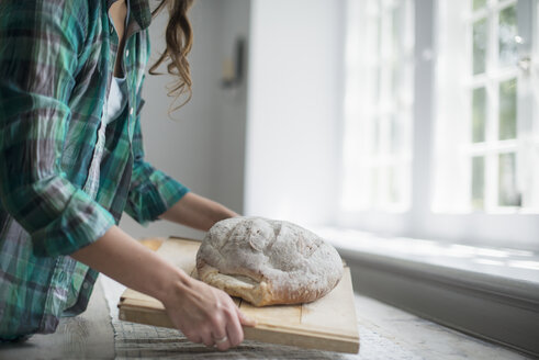 Ein Familientreffen, eine Frau mit einem frisch gebackenen Laib Brot. - MINF01258