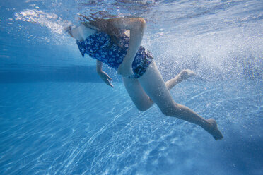 Ein Kind, das in einem Schwimmbad unter Wasser schwimmt. - MINF01280