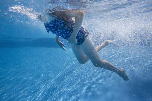 A child swimming under water in a swimming pool. - MINF01280