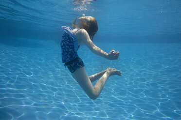 A child swimming under water in a swimming pool. - MINF01282