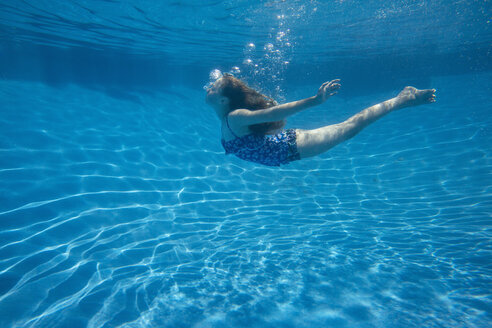 A child swimming under water in a swimming pool. - MINF01283