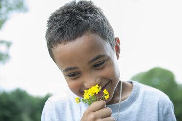 Junge lächelt und hält Blume. - MINF01284
